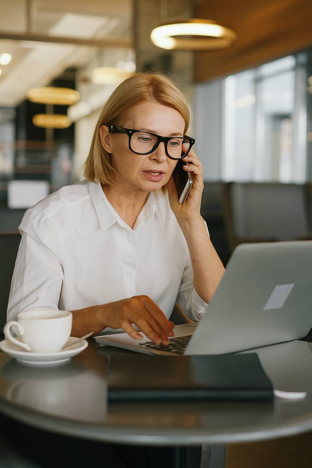 Uma mulher com o celular e notebook